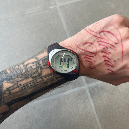 Nike Triax Speed 100 Regular Red Digital Watch features a silver-tone case with four red side buttons and a front button for the backlight function. The watch has an black Nike Swoosh on the top of the case, 100-lap memory, multiple modes, and 100m water resistance. It comes with brown-ish bracelet.

