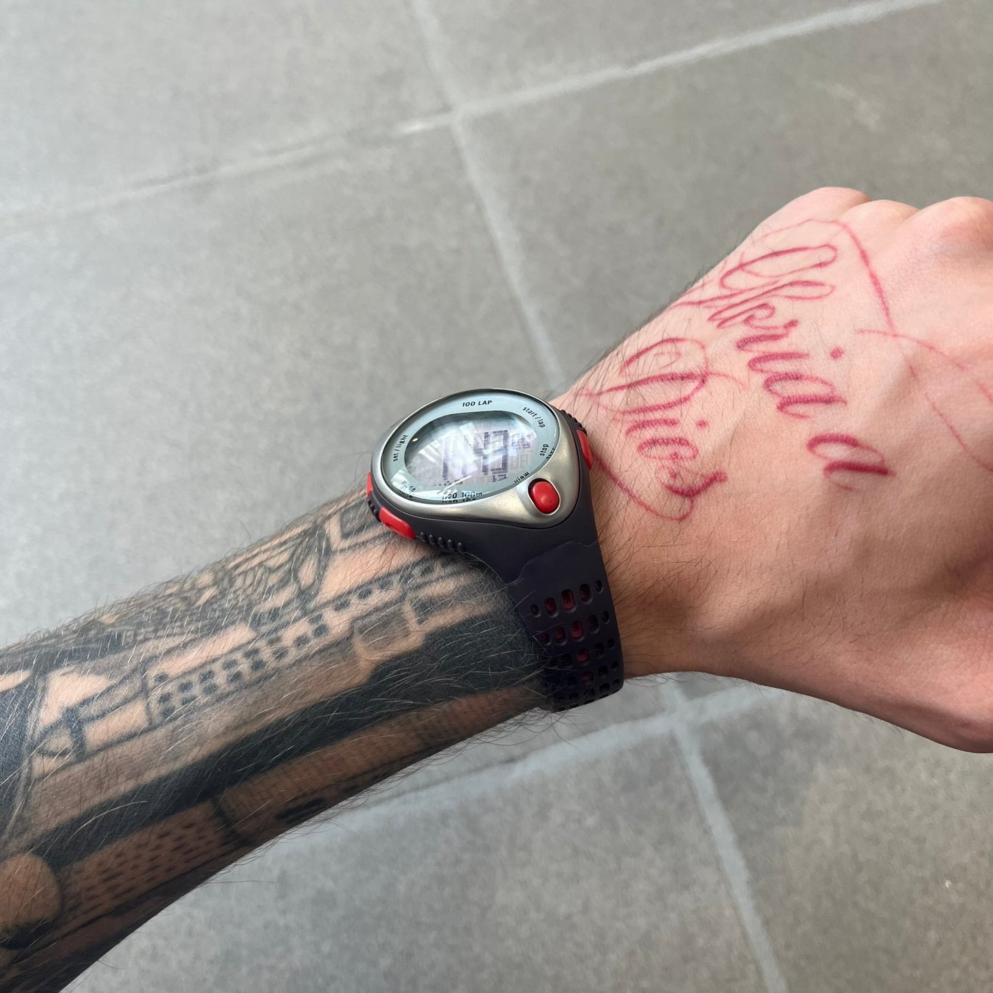 Nike Triax Speed 100 Regular Red Digital Watch features a silver-tone case with four red side buttons and a front button for the backlight function. The watch has an black Nike Swoosh on the top of the case, 100-lap memory, multiple modes, and 100m water resistance. It comes with brown-ish bracelet.
