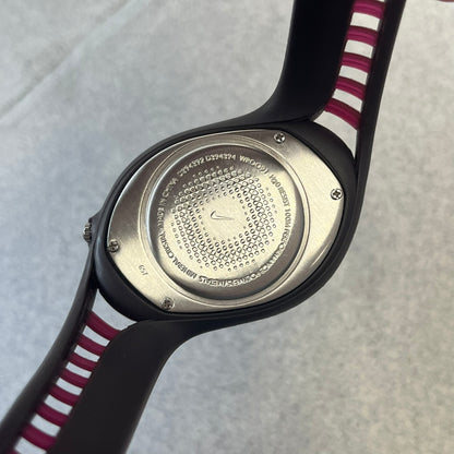 Nike Triax Swift 3i Burgundy WR0091 Analog Watch comes with burgundy and red rubber straps and a silver case featuring a dark Nike Swoosh. The burgundy metallic dial has a dotted pattern, three silver subdials for day, date, and hour and silver hands. Seconds markings are printed on the inner edge of the case and are visible only at an angle.