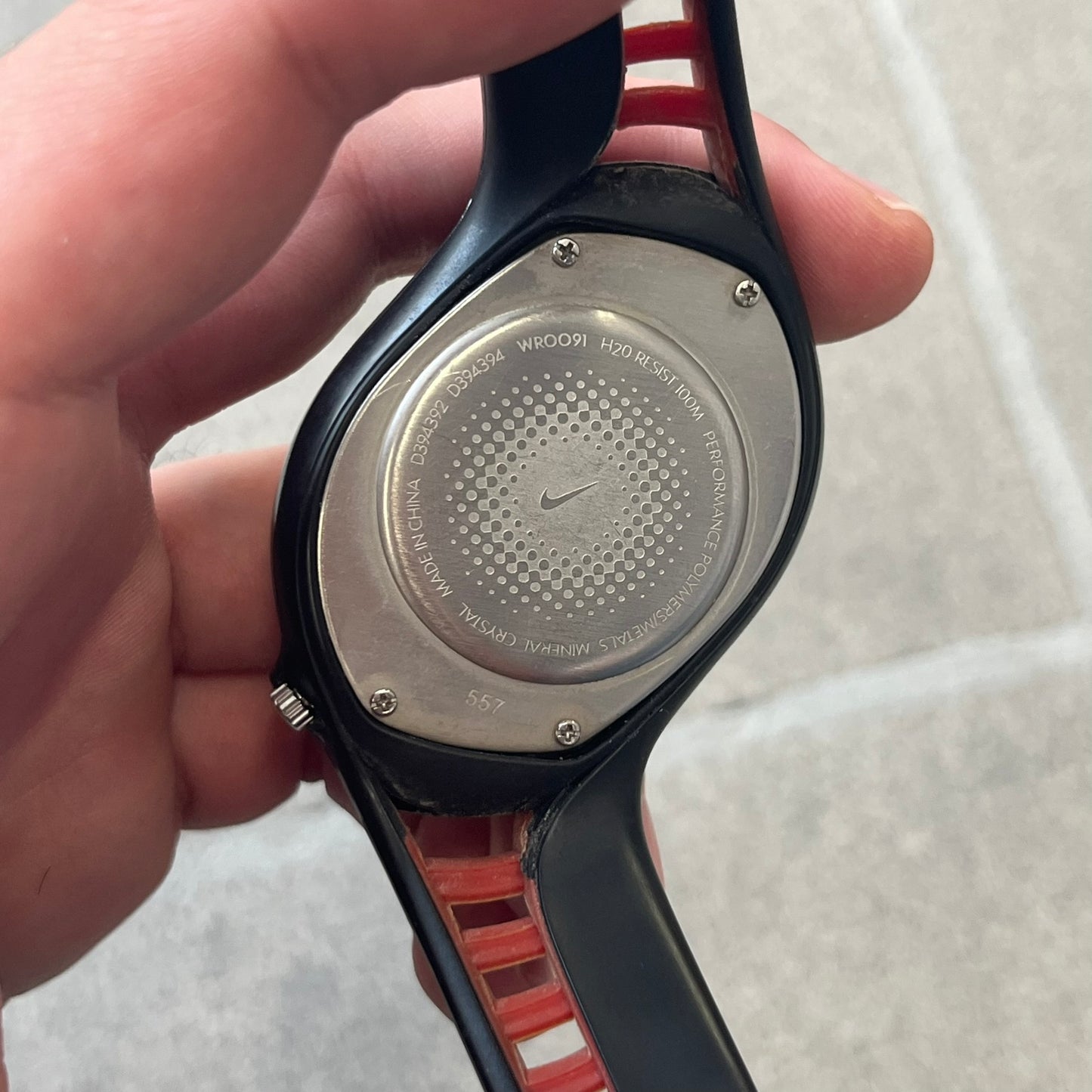 Nike Triax Swift 3i Red WR0091 Analog Watch comes with black &amp; red rubber straps and a black case featuring a red Nike Swoosh. The red metallic dial has a woven pattern, three silver subdials for day, date, and hour and silver hands. Seconds markings are printed on the inner edge of the case and are visible only at an angle. Sport-focused Triax case design with water-resistant construction.
