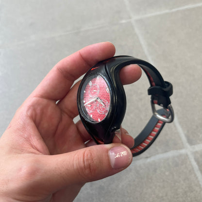Nike Triax Swift 3i Red WR0091 Analog Watch comes with black &amp; red rubber straps and a black case featuring a red Nike Swoosh. The red metallic dial has a woven pattern, three silver subdials for day, date, and hour and silver hands. Seconds markings are printed on the inner edge of the case and are visible only at an angle. Sport-focused Triax case design with water-resistant construction.