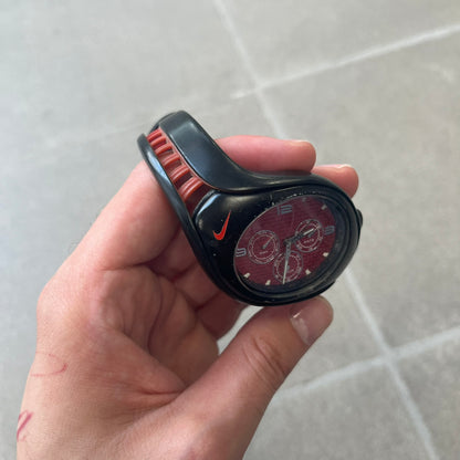 Nike Triax Swift 3i Red WR0091 Analog Watch comes with black &amp; red rubber straps and a black case featuring a red Nike Swoosh. The red metallic dial has a woven pattern, three silver subdials for day, date, and hour and silver hands. Seconds markings are printed on the inner edge of the case and are visible only at an angle. Sport-focused Triax case design with water-resistant construction.