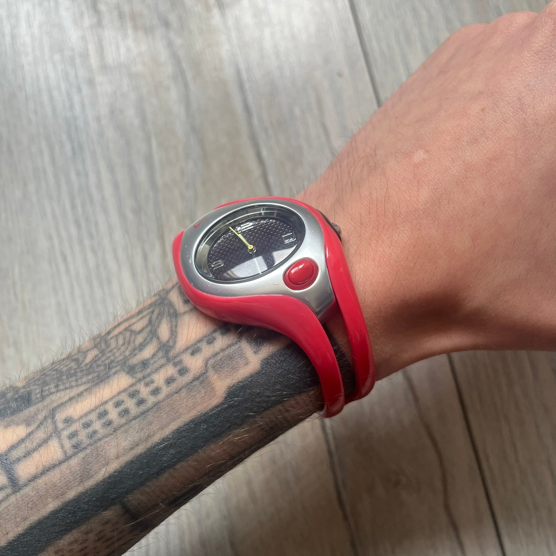 Nike Triax Swift WR0078 analog wristwatch with pink rubber straps and a matching rubber outer case. The internal case is silver-tone metal, fitted with a pink front button and pink Nike Swoosh branding. Features a black dotted dial with silver hands and markers. Sport-oriented construction with a clean, functional layout typical of early-2000s Nike Triax models.