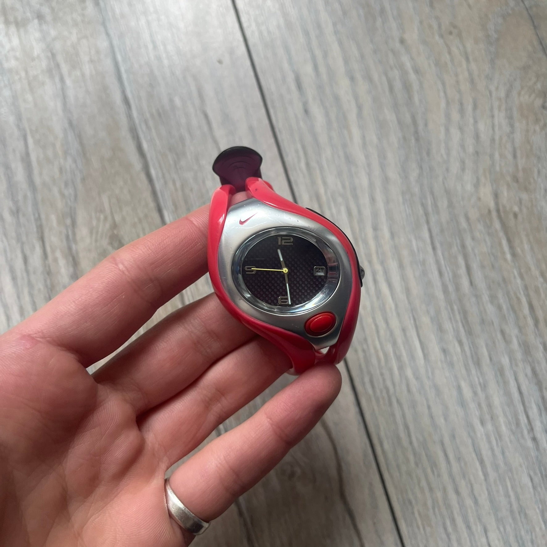 Nike Triax Swift WR0078 analog wristwatch with pink rubber straps and a matching rubber outer case. The internal case is silver-tone metal, fitted with a pink front button and pink Nike Swoosh branding. Features a black dotted dial with silver hands and markers. Sport-oriented construction with a clean, functional layout typical of early-2000s Nike Triax models.