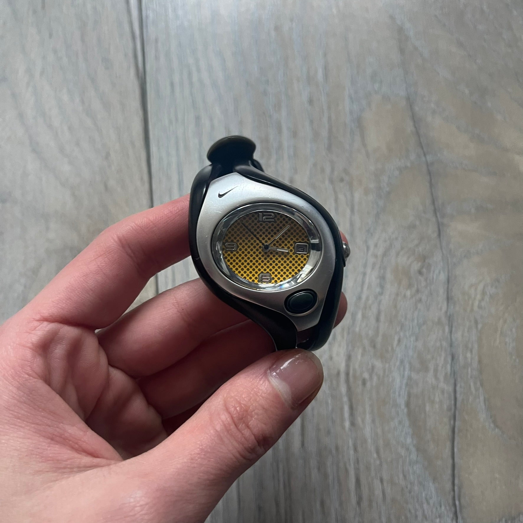 Nike Triax Swift WR0078 analog wristwatch with black rubber straps and a matching rubber outer case. The internal case is silver-tone metal, fitted with a black side button and black Nike Swoosh branding. Features a yellow dotted dial with silver hands and markers. Sport-oriented construction with a clean, functional layout typical of early-2000s Nike Triax models.
