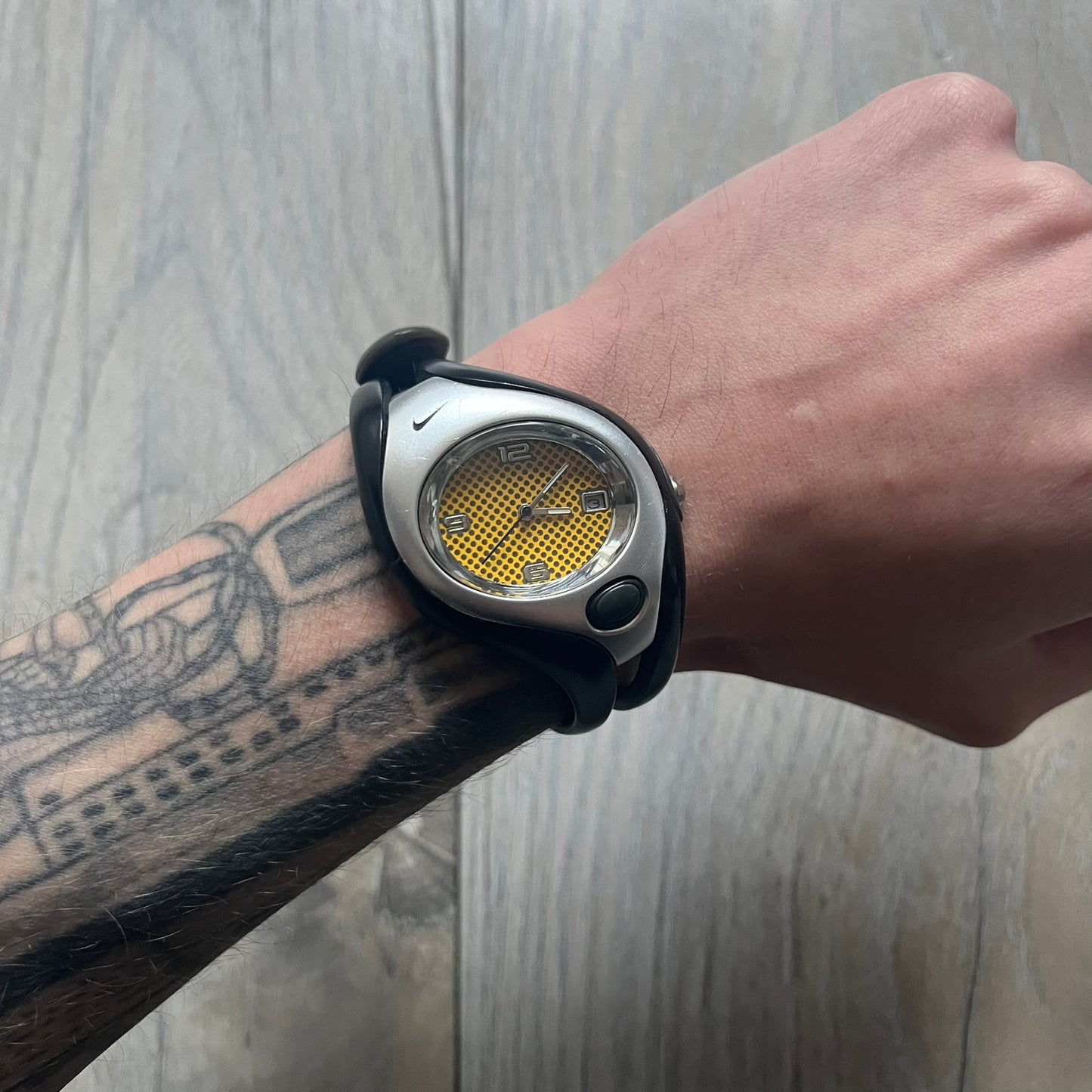 Nike Triax Swift WR0078 analog wristwatch with black rubber straps and a matching rubber outer case. The internal case is silver-tone metal, fitted with a black side button and black Nike Swoosh branding. Features a yellow dotted dial with silver hands and markers. Sport-oriented construction with a clean, functional layout typical of early-2000s Nike Triax models.