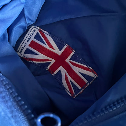 Nike UK Olympics 2008 Split Windbreaker designed by Jarrett Reynolds. Features a blue base with Union Jack-inspired red and white stripes on the front, representing Great Britain. Dual side zippers allow the jacket to be split in half and combined with other pieces from the collection, with a subtle United Kingdom flag inside the pocket.