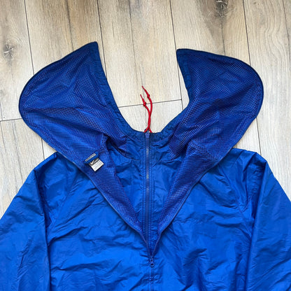 Nike UK Olympics 2008 Split Windbreaker designed by Jarrett Reynolds. Features a blue base with Union Jack-inspired red and white stripes on the front, representing Great Britain. Dual side zippers allow the jacket to be split in half and combined with other pieces from the collection, with a subtle United Kingdom flags inside the pocket.