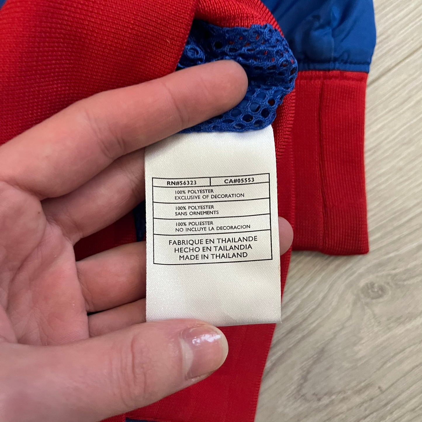 Nike UK Olympics 2008 Split Windbreaker designed by Jarrett Reynolds. Features a blue base with Union Jack-inspired red and white stripes on the front, representing Great Britain. Dual side zippers allow the jacket to be split in half and combined with other pieces from the collection, with a subtle United Kingdom flags inside the pocket.