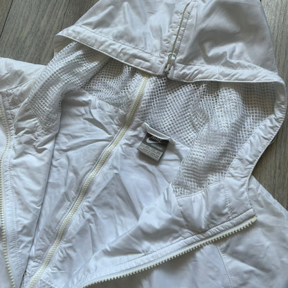 Nike United States (USA) Olympics Split Windbreaker from 2008, created by designer Jarrett Reynolds. Crafted in white, with red hems. Small Nike black embroidery on the chest and back. The upper half of the jacket have slightly visible stars all over. This innovative jacket can be zipped apart on both sides and merged with other compatible models. Hidden inside, a small USA flags accent completes the concept.