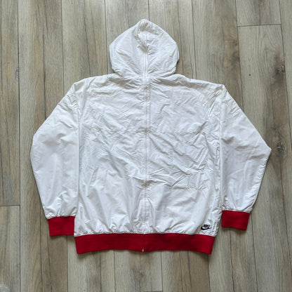 Nike United States (USA) Olympics Split Windbreaker from 2008, created by designer Jarrett Reynolds. Crafted in white, with red hems. Small Nike black embroidery on the chest and back. The upper half of the jacket have slightly visible stars all over. This innovative jacket can be zipped apart on both sides and merged with other compatible models. Hidden inside, a small USA flags accent completes the concept.