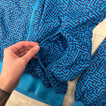 The Nike x Wood Wood “Labyrinth” Split Windbreaker (237110-400) features a full laser blue polyester body with an all-over navy labyrinth print. Designed in Copenhagen, the jacket includes zippers on the front and back allowing it to merge with other compatible models, an embroidered Nike logo and a subtle Wood Wood tag. Inside, a unique printed message from the Wood Wood founders references the jacket’s “Labyrinth” inspiration.