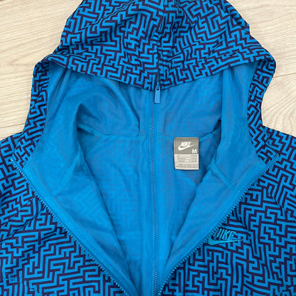 The Nike x Wood Wood “Labyrinth” Split Windbreaker (237110-400) features a full laser blue polyester body with an all-over navy labyrinth print. Designed in Copenhagen, the jacket includes zippers on the front and back allowing it to merge with other compatible models, an embroidered Nike logo and a subtle Wood Wood tag. Inside, a unique printed message from the Wood Wood founders references the jacket’s “Labyrinth” inspiration.