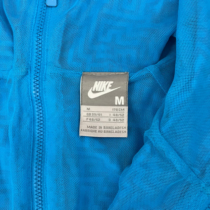 The Nike x Wood Wood “Labyrinth” Split Windbreaker (237110-400) features a full laser blue polyester body with an all-over navy labyrinth print. Designed in Copenhagen, the jacket includes zippers on the front and back allowing it to merge with other compatible models, an embroidered Nike logo and a subtle Wood Wood tag. Inside, a unique printed message from the Wood Wood founders references the jacket’s “Labyrinth” inspiration.