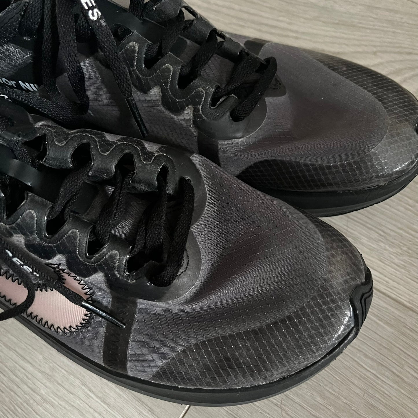 The Nike Zoom Fly Off-White Black Silver (AJ4588-001) reimagines Nike’s running silhouette through Virgil Abloh’s distinct Off-White lens. Built with a semi-translucent upper, black midsole, and bold white Swoosh, this 2018 release merges high-fashion design with advanced running technology.