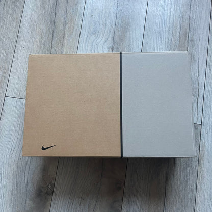 The Nike x NOCTA Hot Step Air Terra “Snakeskin” Light Pumice Sneakers feature a low-top build with a faux snakeskin-textured upper in light pumice blue and grey tones. Details include small 3D mini Swooshes on the sides, reflective piping around the eyestay, oval perforations at the midfoot with a reflective underlay, and NOCTA branding on the tongue and insole. Finished with a white foam midsole inspired by the Air Terra Humara with Zoom Air in the forefoot, a visible Max Air unit in the heel, and a gum ru
