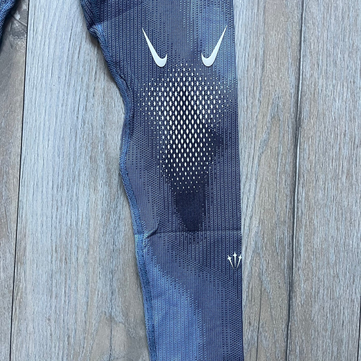 Nike x NOCTA Dri-FIT “Cobalt Bliss” Tights Pants DV3657-479 are men’s slim-fit track tights released on November 8, 2023, as part of the SU2023 collection. The tights feature a Cobalt Bliss blue colorway with light and dark blue (grey-toned) heat map-style patterning throughout, finished with white Nike and NOCTA logos.&nbsp;Constructed with Nike Dri-FIT fabric, they include an elastic waistband with a regular rise and a skinny fit.