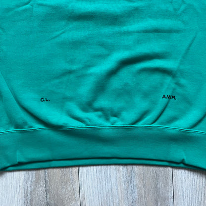 Nike x NOCTA Fleece “Neptune Green” Crewneck Sweatshirt FN8160-370 is a men’s pullover from the Cardinal Stock collection, finished in a Neptune Green/Black colorway. It features a regular fit with a round neckline, long sleeves, elastic cuffs, and an elasticated lower hem.&nbsp;Made from 82% cotton and 18% polyester fleece, the sweatshirt includes a silicone Swoosh logo and signature NOCTA branding, along with a back print, sleeve print, and 3D logo detailing. Made in Vietnam.