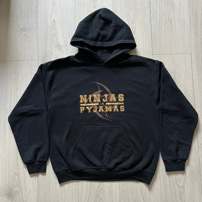 Ninjas In Pyjamas 2010’s Black Hoodie featuring the classic brown NIP logo with gold “Ninjas in Pyjamas” text across the front. Made on a Gildan Heavy Blend blank with a front pocket and adjustable hood. A vintage piece representing one of CS:GO’s most iconic teams.