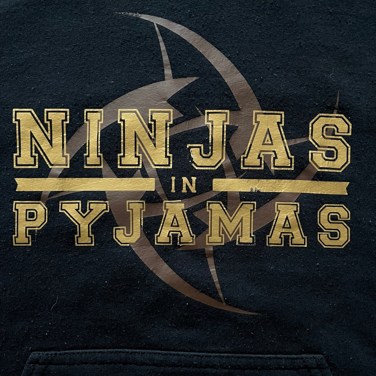 Ninjas In Pyjamas 2010’s Black Hoodie featuring the classic brown NIP logo with gold “Ninjas in Pyjamas” text across the front. Made on a Gildan Heavy Blend blank with a front pocket and adjustable hood. A vintage piece representing one of CS:GO’s most iconic teams.