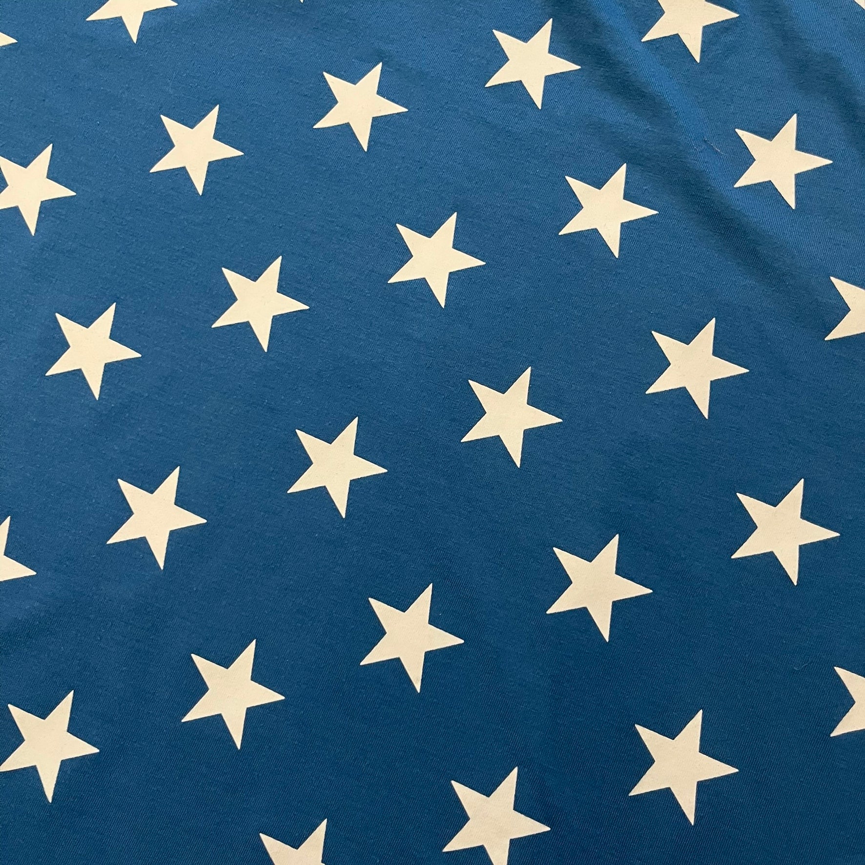 Oakley Crazy Stars Tee in blue with an all-over white star print covering the top two-thirds of the front, back, and sleeves. Features a large Oakley “O” logo on the front. Made from a cotton/polyester blend in El Salvador.