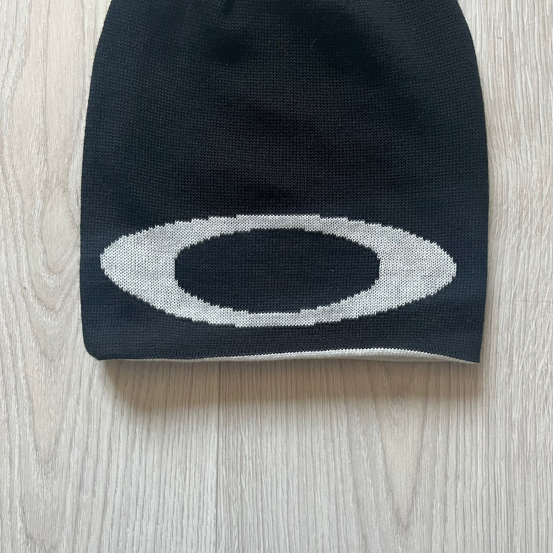 Oakley Ellipse Beanie Black crafted from soft 100% acrylic fabric with a reversible two-sided build. Includes Oakley’s signature Center white ellipse logo on the front. Designed for casual wear and outdoor performance with reliable warmth and fit.