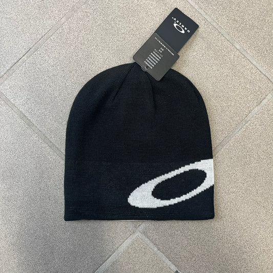 Oakley Ellipse Black Side Beanie is a classic-fit, fine-knit beanie made from 100% acrylic, with a reversible two-sided build. It has a contrasting white jacquard Oakley Ellipse logo on the side and a small logo flag. Designed for casual wear and outdoor performance with reliable warmth and fit.