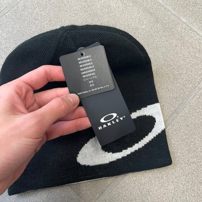 Oakley Ellipse Black Side Beanie is a classic-fit, fine-knit beanie made from 100% acrylic, with a reversible two-sided build. It has a contrasting white jacquard Oakley Ellipse logo on the side and a small logo flag. Designed for casual wear and outdoor performance with reliable warmth and fit.