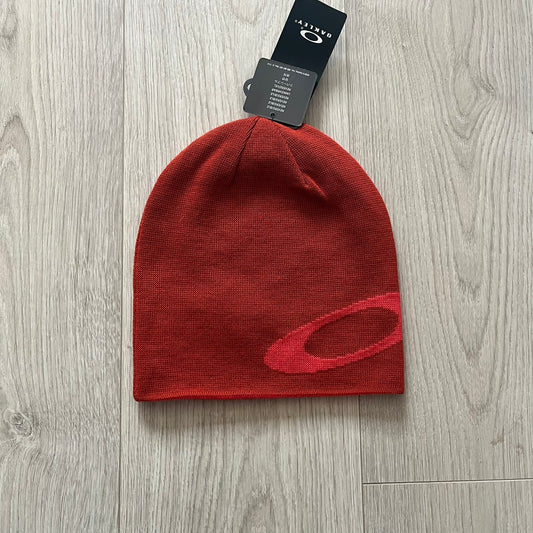 Oakley Side Ellipse beanie in flame red featuring a tilted lighter red O ellipse logo on the side. Reversible design and 100% acrylic construction make it both versatile and cozy. A clean, standout piece for casual and outdoor looks.