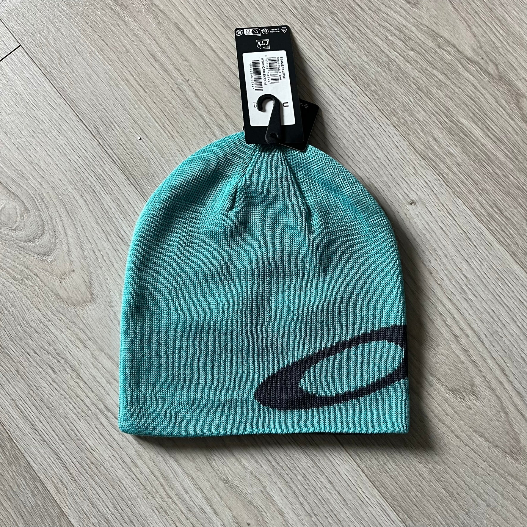 Oakley Turquoise Side Ellipse Beanie crafted from soft 100% acrylic fabric with a reversible two-sided build. Includes Oakley’s signature dark navy ellipse logo on the side. Designed for casual wear and outdoor performance with reliable warmth and fit.