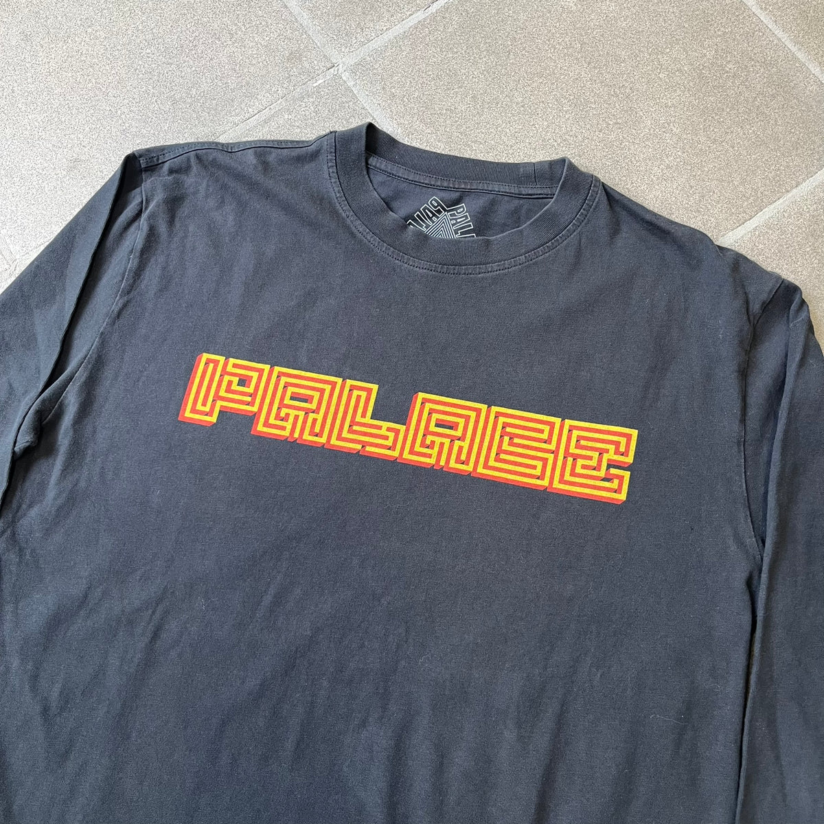 Palace FW18 Mazin Black Longsleeve features a black 100% cotton construction with a Palace logo printed on the chest. The logo is made from a maze-style graphic in yellow and red. Released on November 23, 2018.