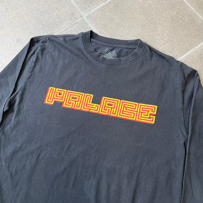 Palace FW18 Mazin Black Longsleeve features a black 100% cotton construction with a Palace logo printed on the chest. The logo is made from a maze-style graphic in yellow and red. Released on November 23, 2018.