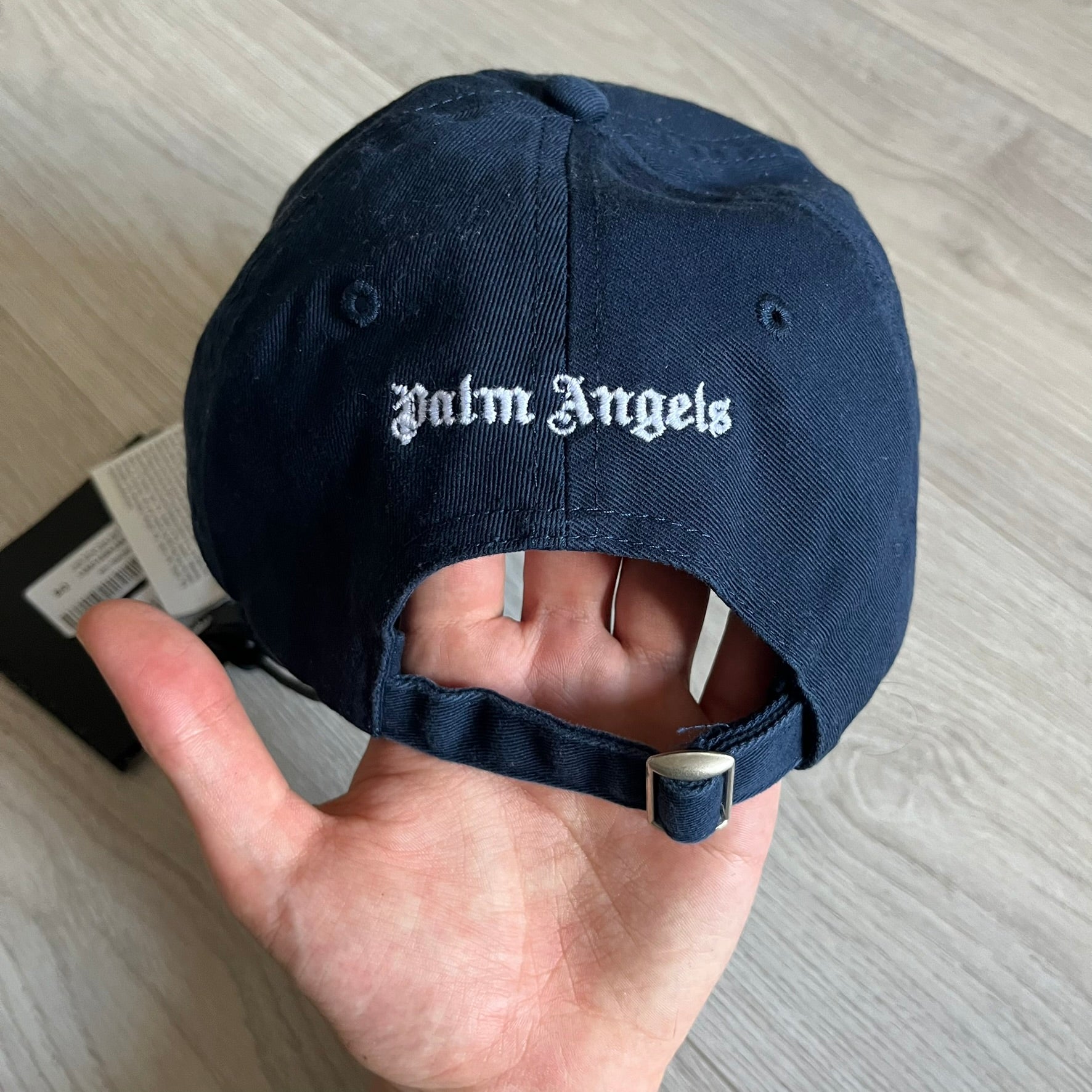 Palm Angels Classic Logo Navy Baseball Cap crafted from 100% cotton. Features white embroidered Palm Angels logos on the front and back in gothic-inspired lettering. A timeless streetwear accessory with a clean navy finish.