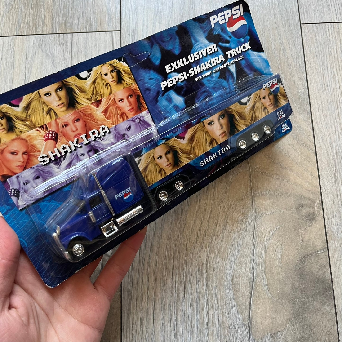 Pepsi 2000’s Shakira 1:87 Delivery Truck Model is a limited edition promotional model featuring a blue Pepsi delivery truck covered with graphics of Shakira alongside Pepsi logos and name text. The model remains in its original clear plastic display case attached to a printed cardboard backing with Pepsi and Shakira branding. This German edition promotional piece was produced as part of early 2000s Pepsi marketing campaigns.