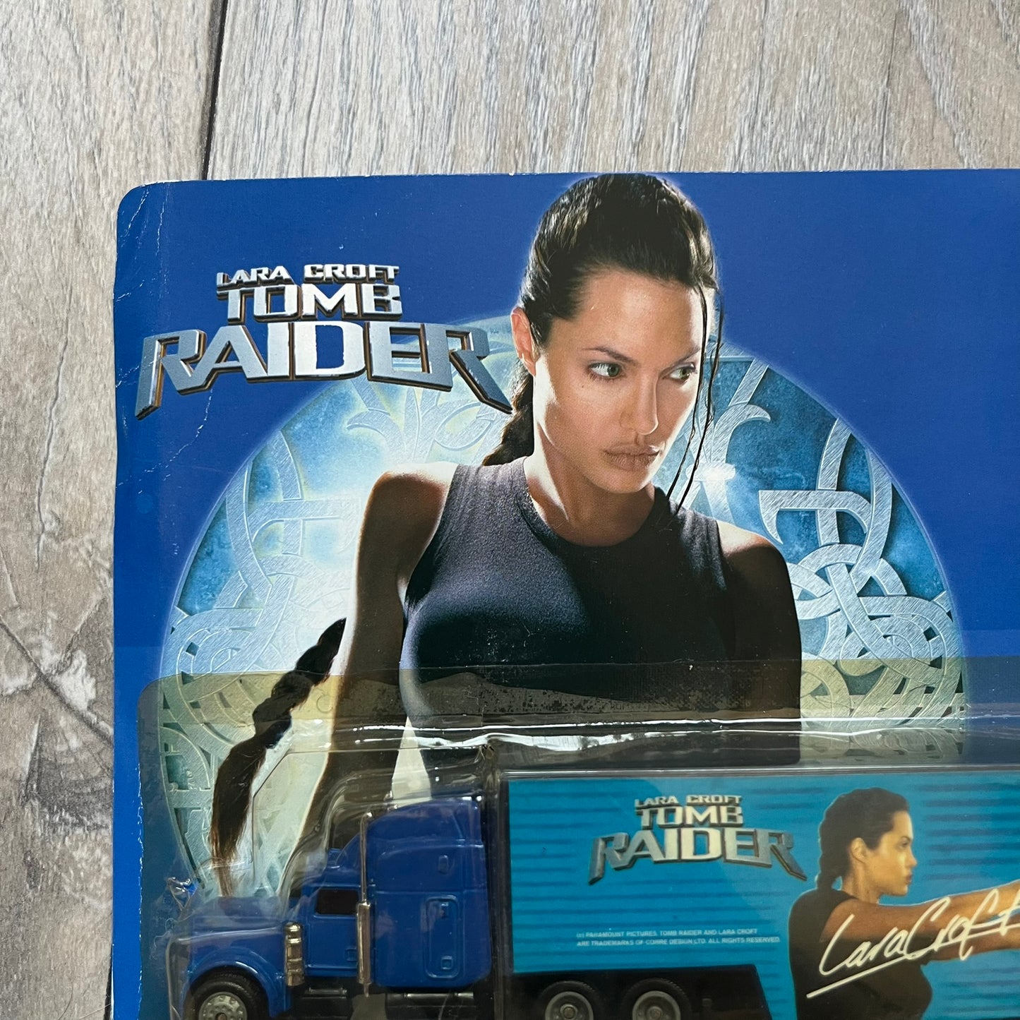 Pepsi 2001 Lara Croft Tomb Raider 1:87 Delivery Truck Model is a promotional die-cast style truck released alongside the film Lara Croft: Tomb Raider. The model features a blue Pepsi delivery truck with a large graphic of Lara Croft and Pepsi branding on the sides. It comes displayed in a clear plastic case attached to a printed cardboard backing with Tomb Raider and Pepsi graphics. The bottom of the case includes 2001 Paramount Pictures licensing.