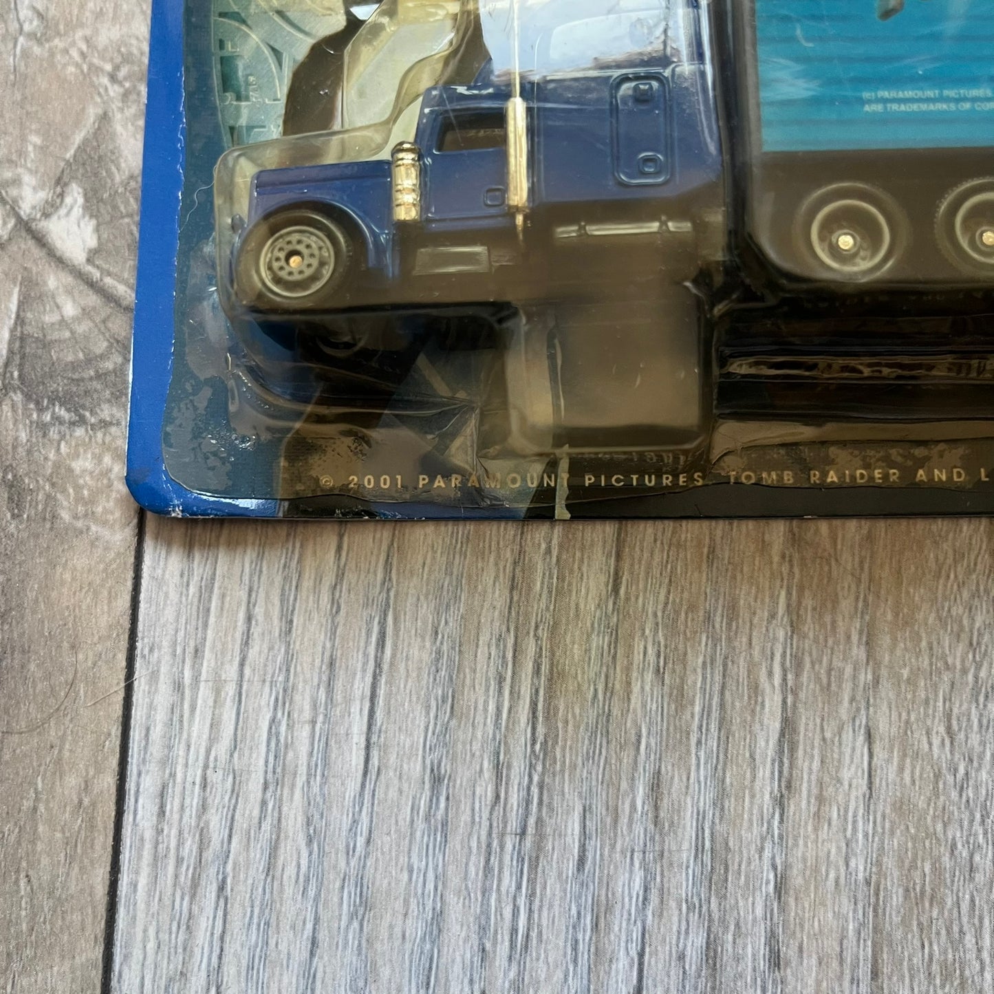 Pepsi 2001 Lara Croft Tomb Raider 1:87 Delivery Truck Model is a promotional die-cast style truck released alongside the film Lara Croft: Tomb Raider. The model features a blue Pepsi delivery truck with a large graphic of Lara Croft and Pepsi branding on the sides. It comes displayed in a clear plastic case attached to a printed cardboard backing with Tomb Raider and Pepsi graphics. The bottom of the case includes 2001 Paramount Pictures licensing.