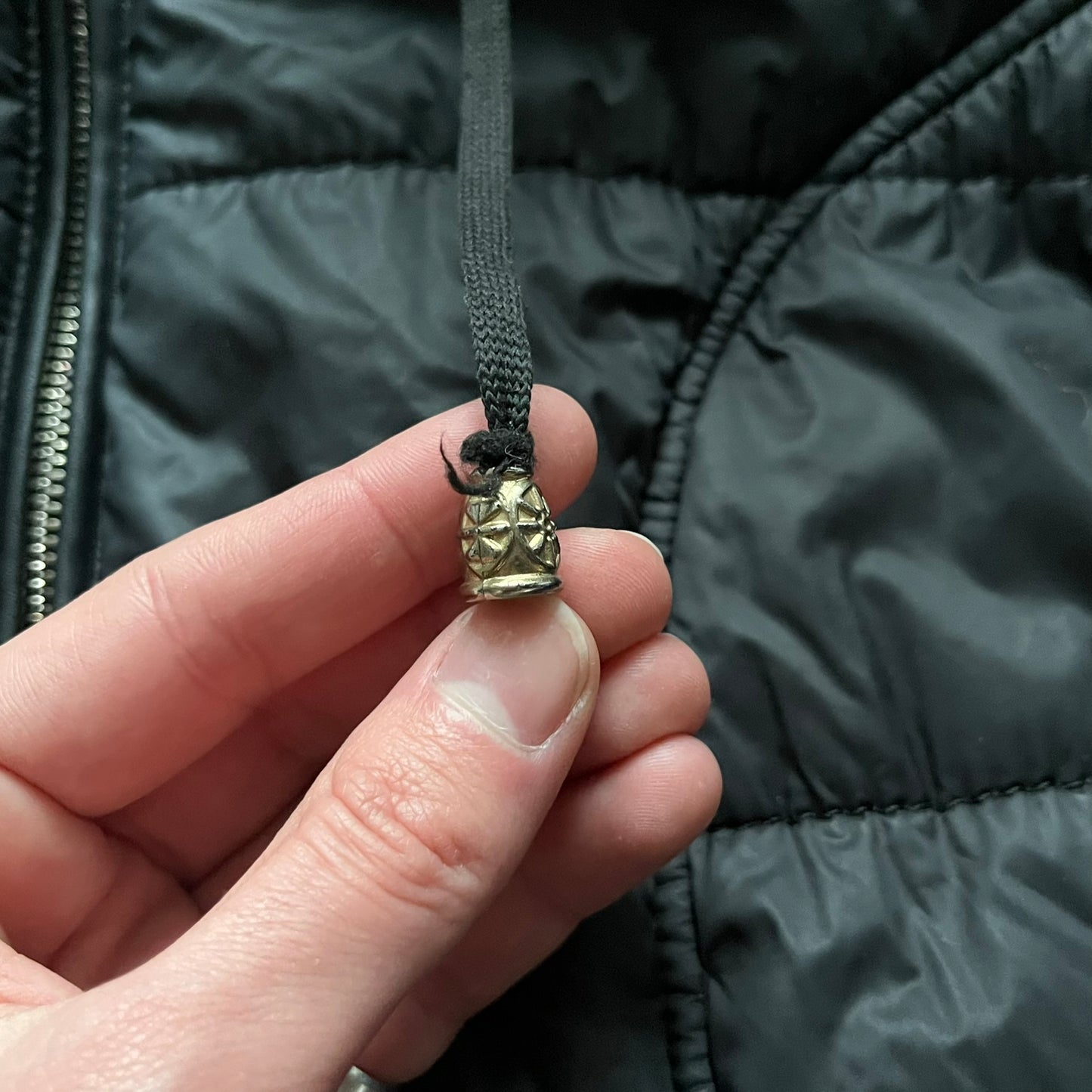Philipp Plein 2010's Fur Hood Puffer Jacket is a black puffer jacket with a removable fur-trimmed hood attached by zipper. The jacket features heavy silver-tone hardware throughout, including 3 large zipper pulls used on the front pockets, main zipper and one drawstring ending. The right arm has a black “P” patch set with crystals.
