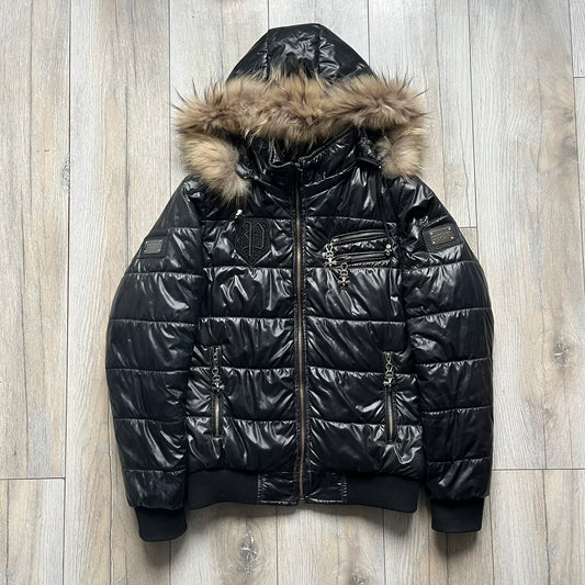 Philipp Plein 2010s Black Waxed Puffer Jacket is a black puffer jacket with a removable fur-trimmed hood attached by zipper. The jacket features heavy silver-tone hardware throughout, including large zipper pulls shaped as crosses with a skull in the center, used on the front pockets and chest pockets. The right chest has a black “P” patch set with crystals, while the left chest features two zip pockets. The hood drawstrings are finished with silver skull tips marked with a “P.”

Both shoulders are finished