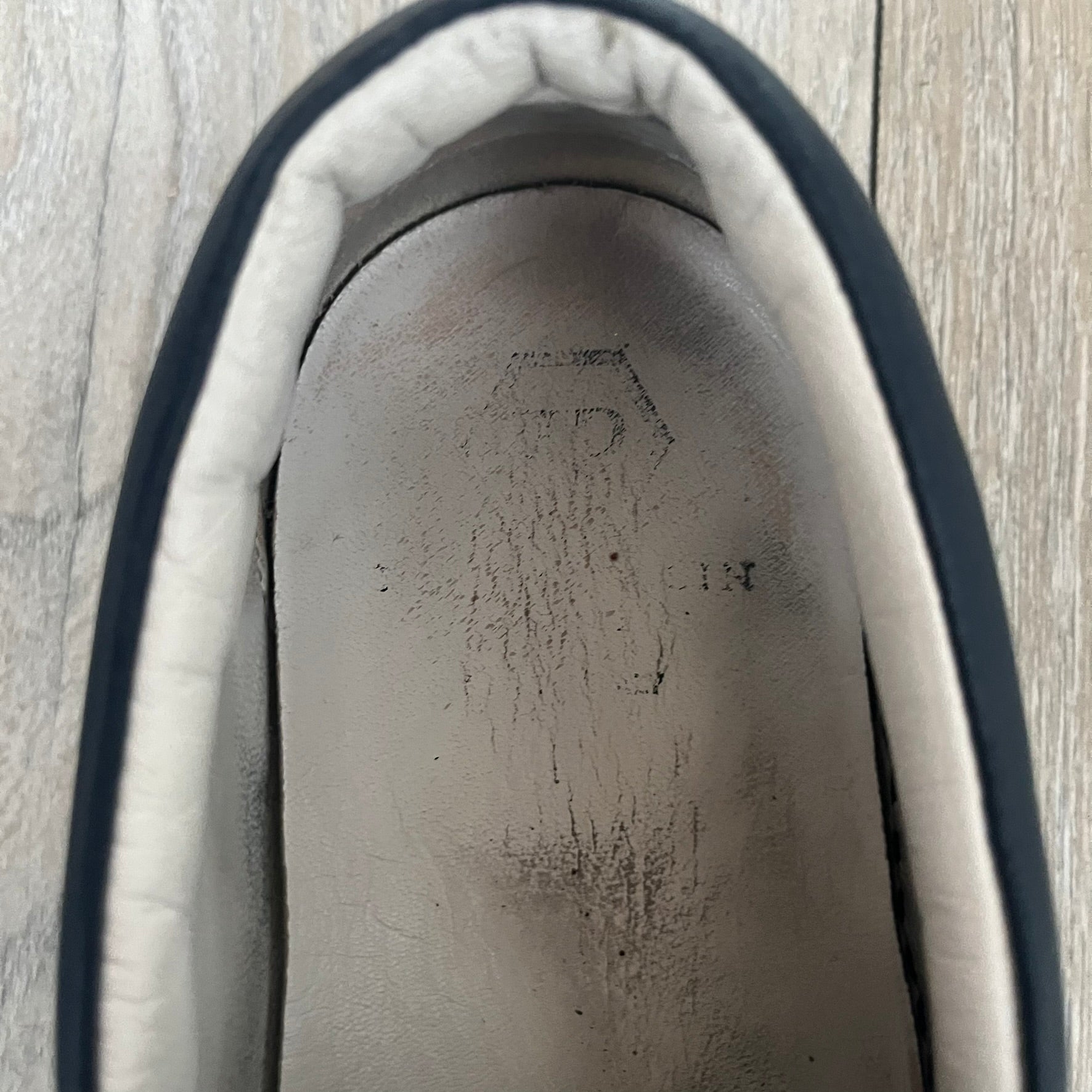 Philipp Plein Navy Skull Slip-Ons are dark navy slip-on sneakers with white interior lining. The front features large raised skull logos, while the sole side displays the Philipp Plein text/logo. Made in Italy, the interior includes an authentic PP tag.