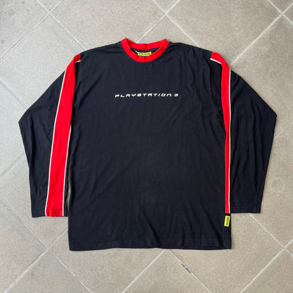 PlayStation 3 Game Mania Crew 2000s Longsleeve is a black long-sleeve shirt featuring red collar and shoulder stripe detailing running along the tops of the sleeves. The front displays a white PlayStation 3 logo, while the back is printed with the "Game Mania" logo above "CREW" lettering. Finished with distinctive yellow Game Mania neck tag, this event/store-exclusive piece was produced for Game Mania staff and promotional use.
