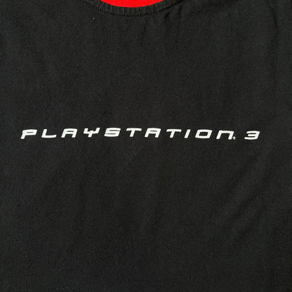 PlayStation 3 Game Mania Crew 2000s Longsleeve is a black long-sleeve shirt featuring red collar and shoulder stripe detailing running along the tops of the sleeves. The front displays a white PlayStation 3 logo, while the back is printed with the "Game Mania" logo above "CREW" lettering. Finished with distinctive yellow Game Mania neck tag, this event/store-exclusive piece was produced for Game Mania staff and promotional use.