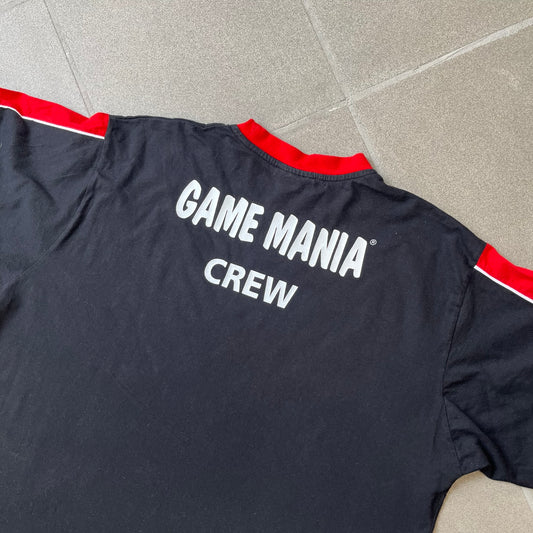PlayStation 3 Game Mania Crew 2000s Longsleeve is a black long-sleeve shirt featuring red collar and shoulder stripe detailing running along the tops of the sleeves. The front displays a white PlayStation 3 logo, while the back is printed with the "Game Mania" logo above "CREW" lettering. Finished with distinctive yellow Game Mania neck tag, this event/store-exclusive piece was produced for Game Mania staff and promotional use.
