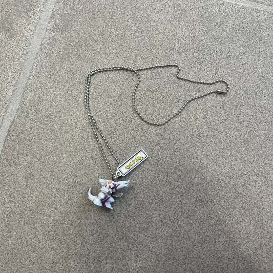 Pokémon 2008 Palkia Necklace is a converted Palkia key chain turned into a wearable pendant. It features a small 3D Palkia figure from the Pokémon franchise with an attached Pokémon tag containing licensing details on the back. The pendant design comes from a 2008 key chain release.