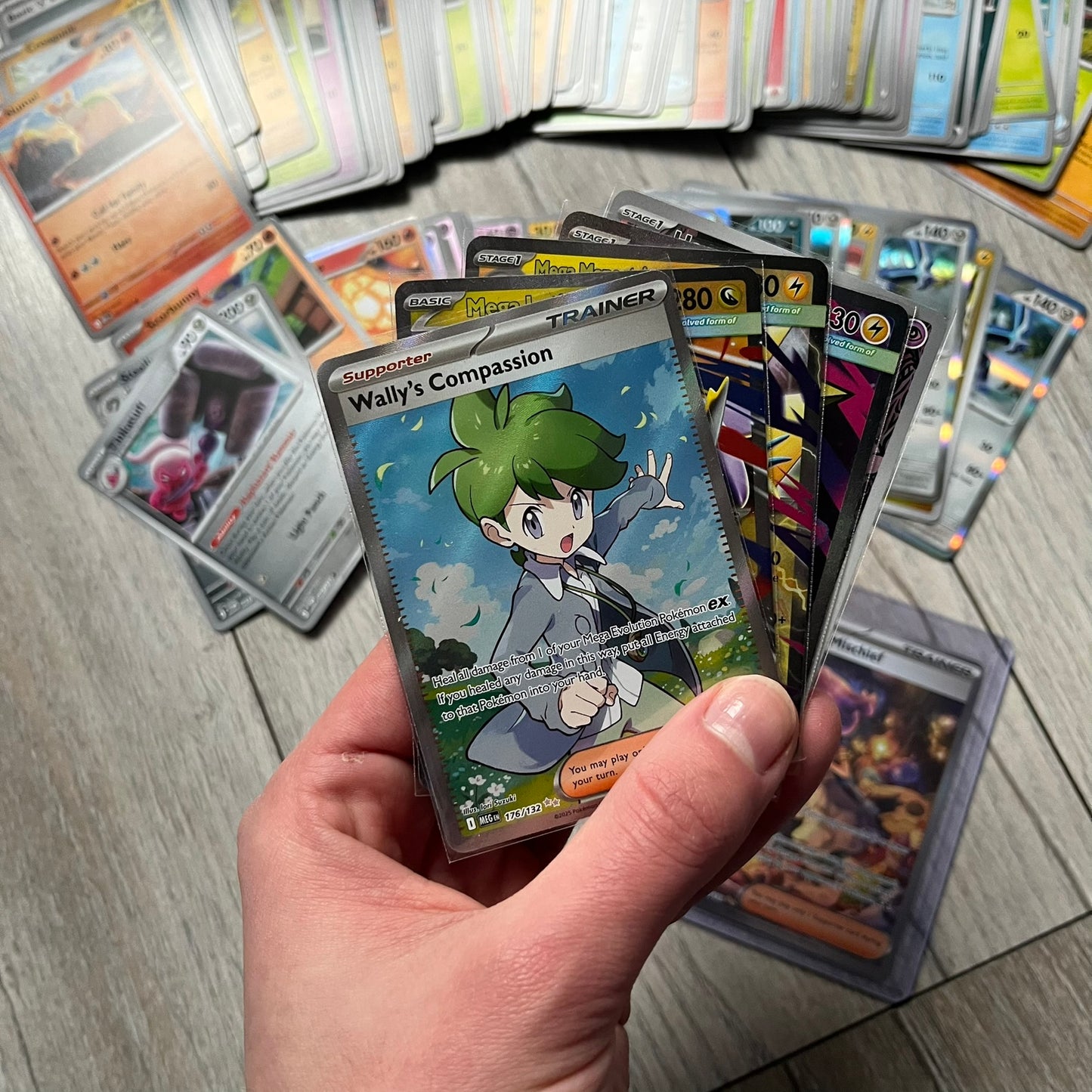 Pokémon TCG: Mega Evolution Phantasmal Flames – 100 Cards includes a collection of 100 trading cards from the Mega Evolution Phantasmal Flames booster series. The set features notable cards such as Acerola’s Mischief and Wally’s Compassion.&nbsp;