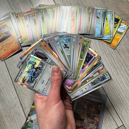 Pokémon TCG: Mega Evolution Phantasmal Flames – 100 Cards includes a collection of 100 trading cards from the Mega Evolution Phantasmal Flames booster series. The set features notable cards such as Acerola’s Mischief and Wally’s Compassion.&nbsp;