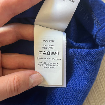 Polo Ralph Lauren x Fortnite 2022 Polo Shirt featuring a two-tone split design in blue and navy with a crisp white collar. The front showcases a large white panel with “2022” text, Ralph Lauren Est. 1967 branding, and a Fortnite logo, along with an oversized embroidered Polo logo above. A limited collaboration piece combining Ralph Lauren’s heritage aesthetic with Fortnite’s playful edge.