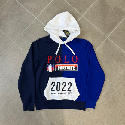 Polo Ralph Lauren x Fortnite 2022 Hoodie featuring a two-tone split design in blue and navy with a white hood. The front showcases a large white panel with “2022” text, Ralph Lauren Est. 1967 branding, and a Fortnite logo, along with an oversized embroidered Polo logo above. A limited collaboration piece with paper tags.