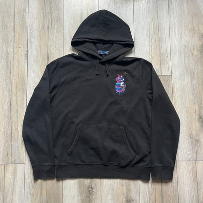 Polo Ralph Lauren x Fortnite black hoodie featuring a detailed embroidered purple Fortnite llama with the RL rider logo placed on top. Made from a 66% cotton and 34% polyester blend, it has a classic pullover construction with an attached hood and front kangaroo pocket. The embroidery is positioned on the left chest and stands out with clean stitching and sharp detail.