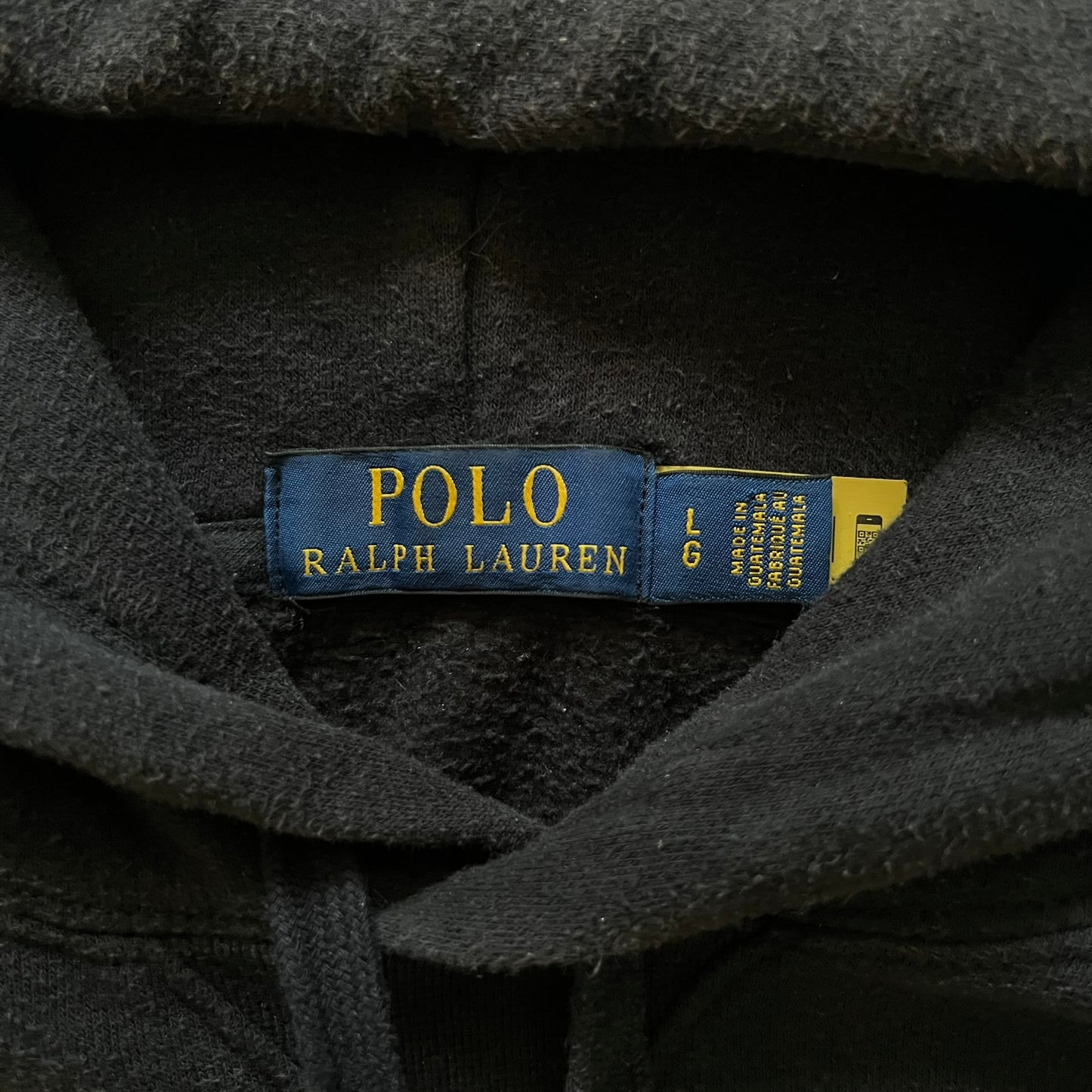  Polo Ralph Lauren x Fortnite black hoodie featuring a detailed embroidered purple Fortnite llama with the RL rider logo placed on top. Made from a 66% cotton and 34% polyester blend, it has a classic pullover construction with an attached hood and front kangaroo pocket. The embroidery is positioned on the left chest and stands out with clean stitching and sharp detail.