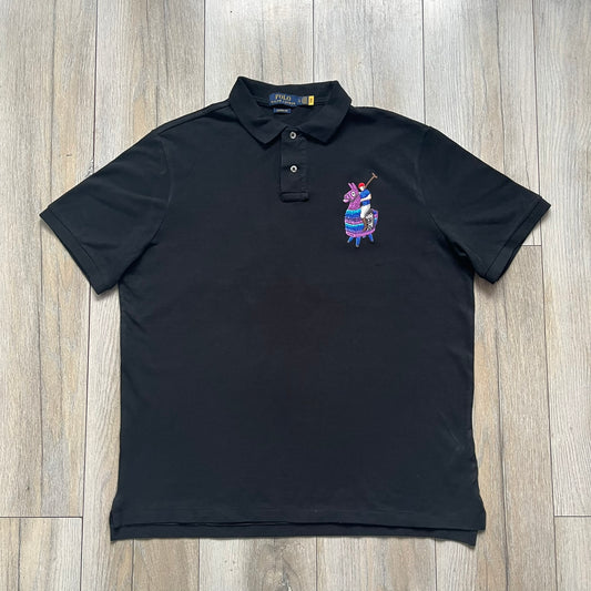 Polo Ralph Lauren x Fortnite 2022 Embroidered Llama Polo is a black cotton polo shirt from the 2022 collaboration collection. It features a classic fit with a two-button collar design and an embroidered chest logo replacing the traditional Ralph Lauren horse with the iconic Fortnite llama in purple and blue tones. Made from 100% cotton.
